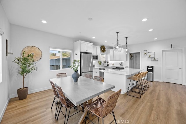 dining area featuring sink and light hardwood / wood-style flooring