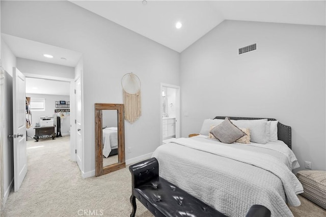 bedroom with high vaulted ceiling, ensuite bath, and light colored carpet