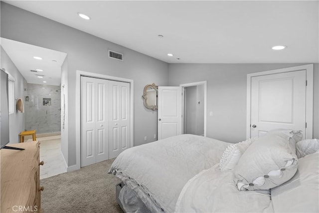 carpeted bedroom with vaulted ceiling, ensuite bath, and a closet