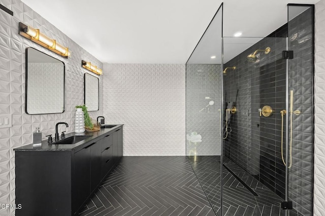 bathroom featuring vanity, a shower with door, and tile walls