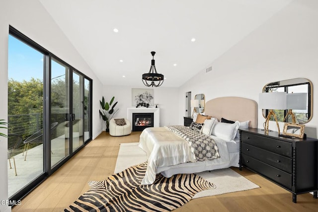 bedroom with lofted ceiling, light hardwood / wood-style floors, and access to outside