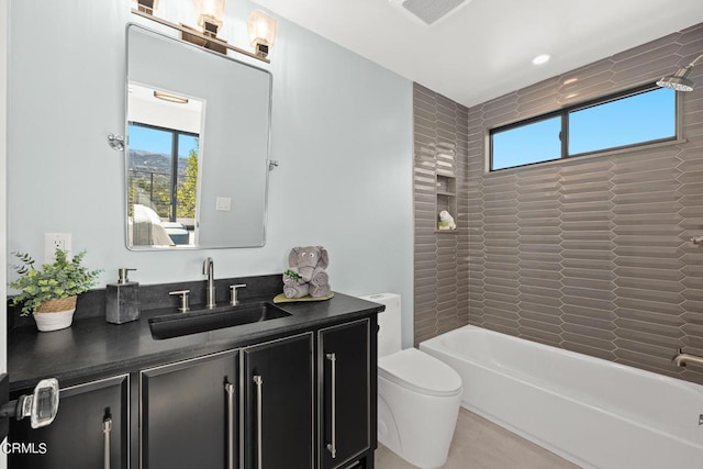 full bathroom featuring tiled shower / bath, a healthy amount of sunlight, toilet, and vanity