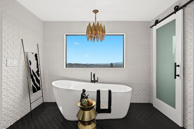 bathroom featuring a chandelier and a bathing tub