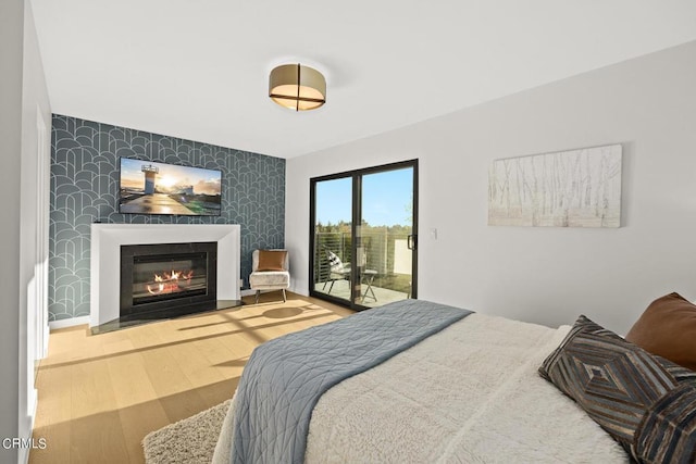 bedroom featuring access to exterior and hardwood / wood-style floors