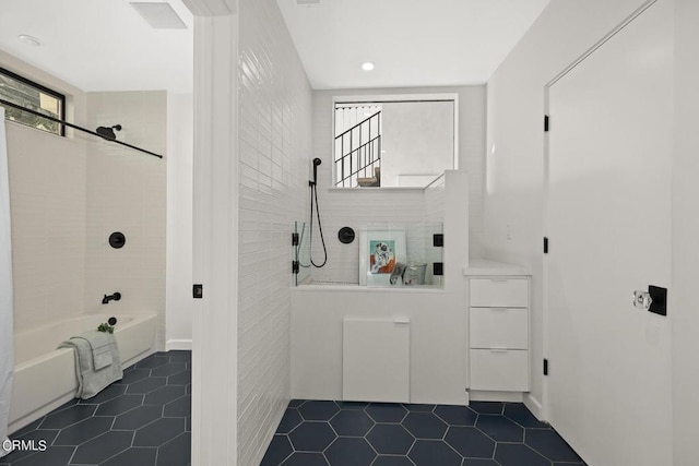 bathroom featuring tile walls, tile patterned floors, and tiled shower / bath