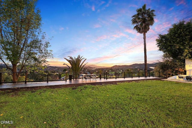 yard at dusk featuring a mountain view and a patio area