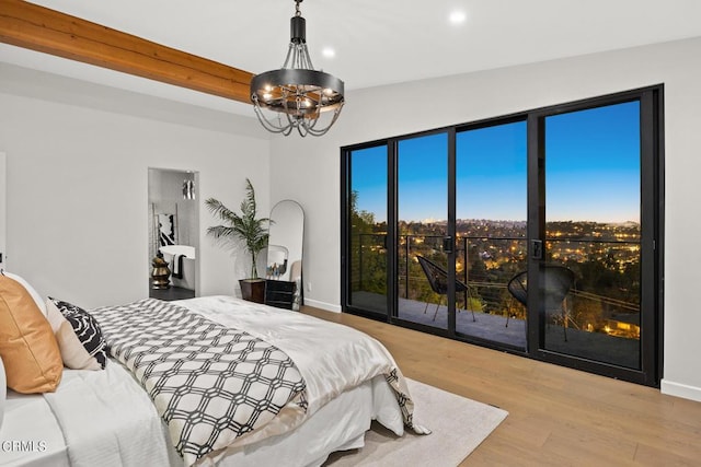 bedroom featuring lofted ceiling, access to outside, a chandelier, and light wood-type flooring