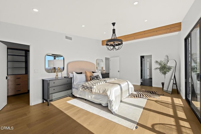 bedroom featuring light hardwood / wood-style flooring and a chandelier