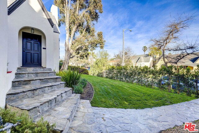 view of exterior entry with a yard