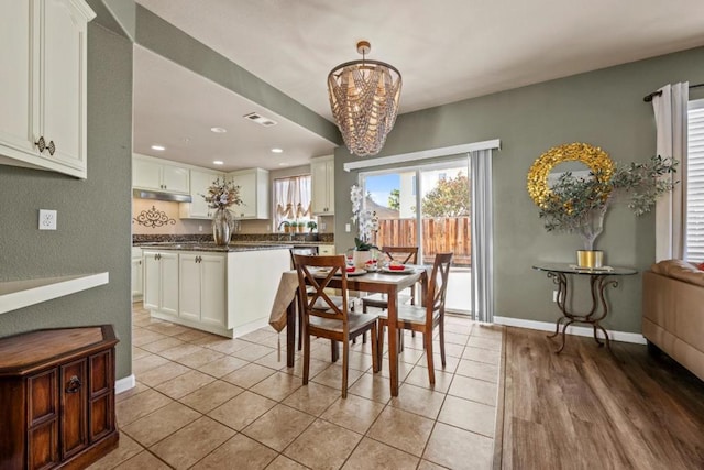 dining room featuring a notable chandelier, light tile patterned floors, and sink