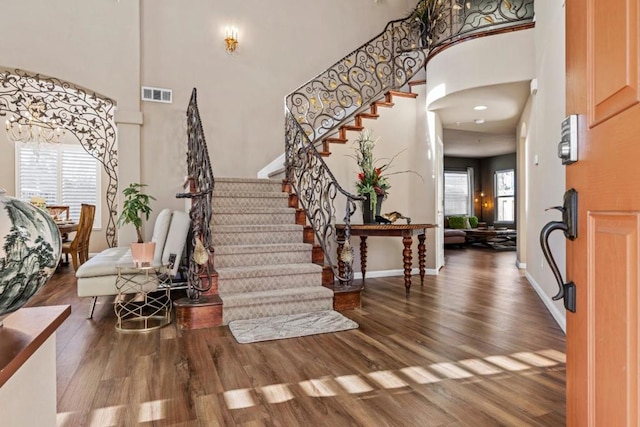 entryway featuring a towering ceiling and hardwood / wood-style floors