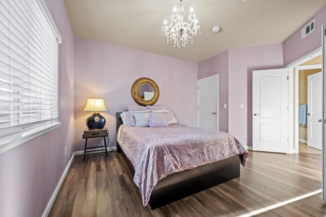 bedroom with dark wood-type flooring and a notable chandelier