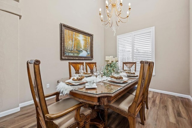 dining space featuring wood-type flooring and a chandelier