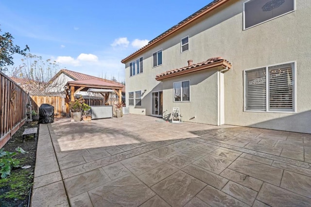 rear view of house with a gazebo and a patio