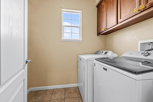 washroom featuring cabinets, light tile patterned floors, and washer and clothes dryer