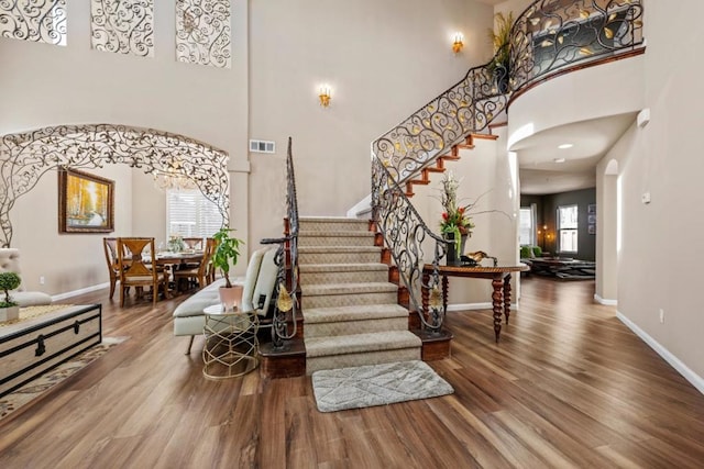 entrance foyer with hardwood / wood-style floors and a high ceiling