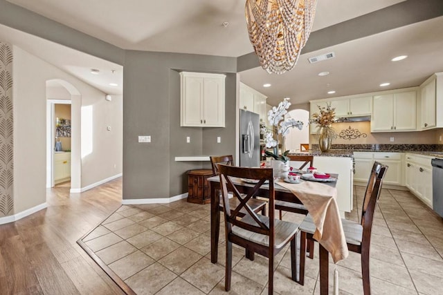 tiled dining space with a notable chandelier