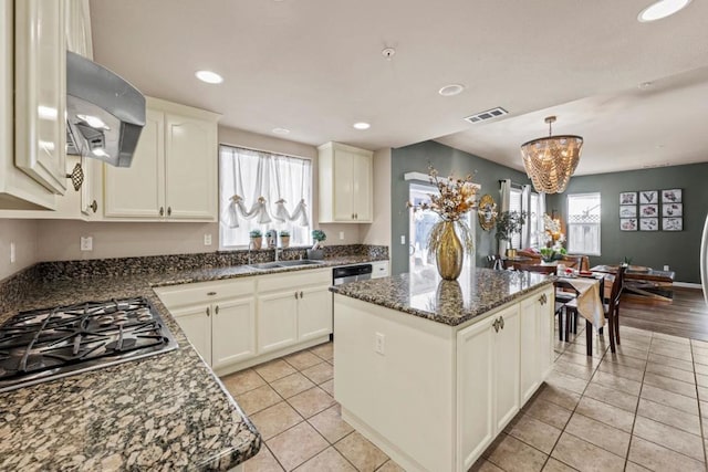 kitchen with sink, light tile patterned floors, range hood, a kitchen island, and stainless steel gas stovetop