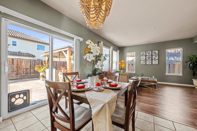 dining room with light tile patterned flooring and an inviting chandelier