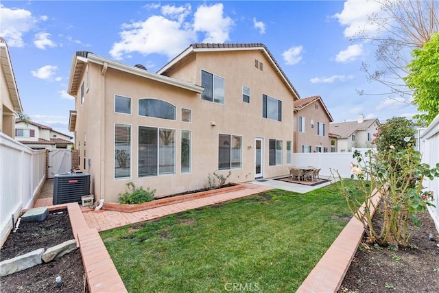 rear view of property with central AC, a patio, and a lawn