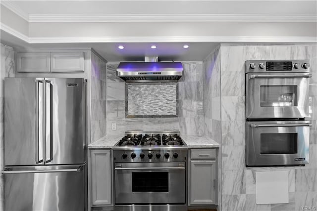 kitchen featuring extractor fan, gray cabinetry, light stone countertops, and premium appliances