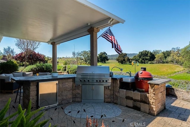 view of patio / terrace featuring an outdoor kitchen, a grill, and a bar