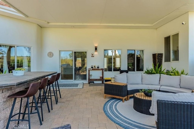 view of patio with an outdoor living space and a bar