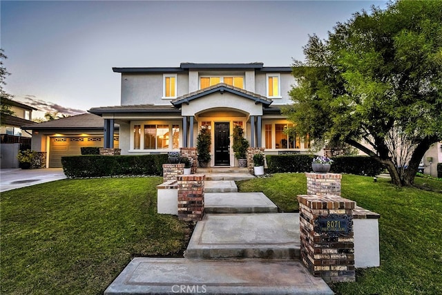 view of front of property with a garage and a yard