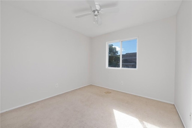 spare room with light colored carpet and ceiling fan