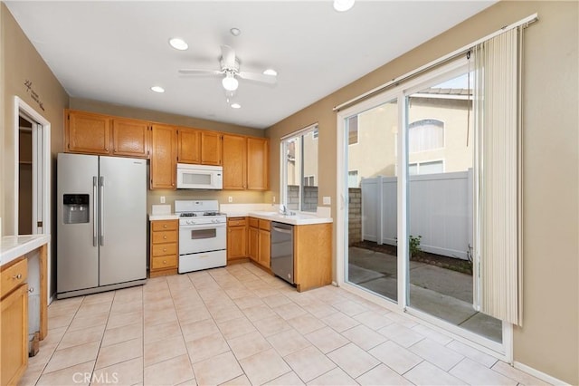 kitchen with light tile patterned flooring, ceiling fan, stainless steel appliances, and sink