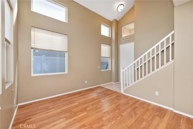 foyer with high vaulted ceiling and light wood-type flooring