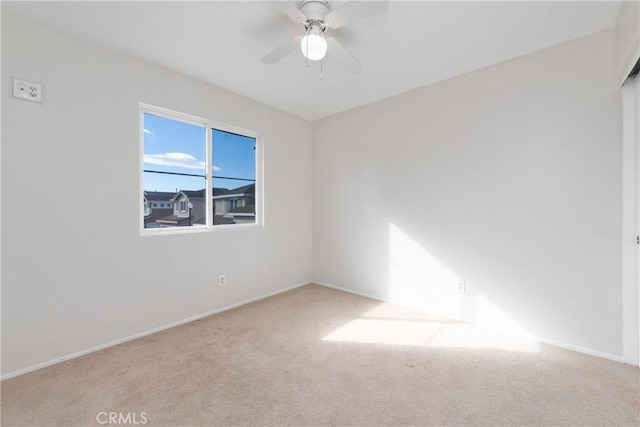 spare room featuring light colored carpet and ceiling fan