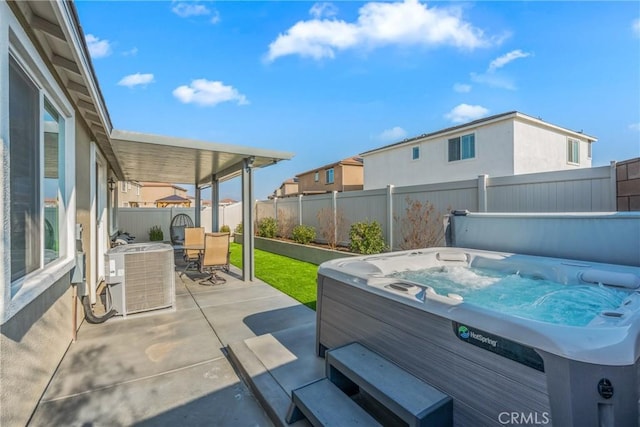 view of patio / terrace with a hot tub and central AC unit