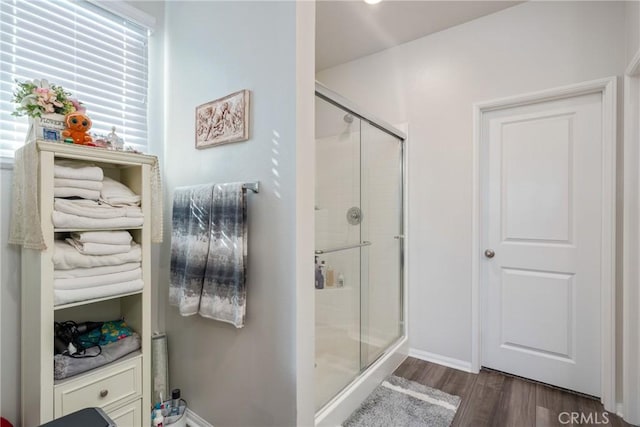 bathroom featuring wood-type flooring and a shower with door