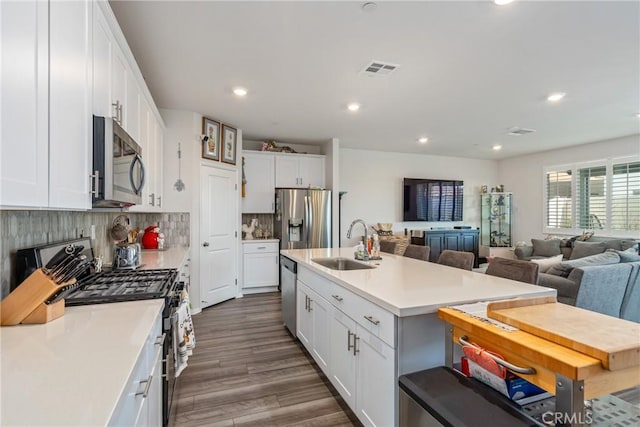 kitchen featuring white cabinetry, sink, an island with sink, and appliances with stainless steel finishes