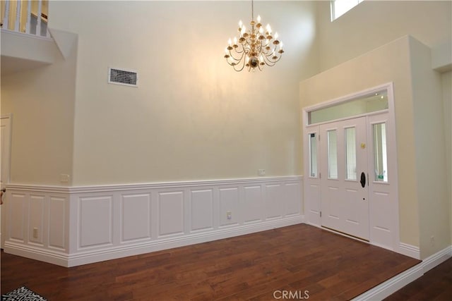 entrance foyer featuring dark wood-type flooring and a chandelier