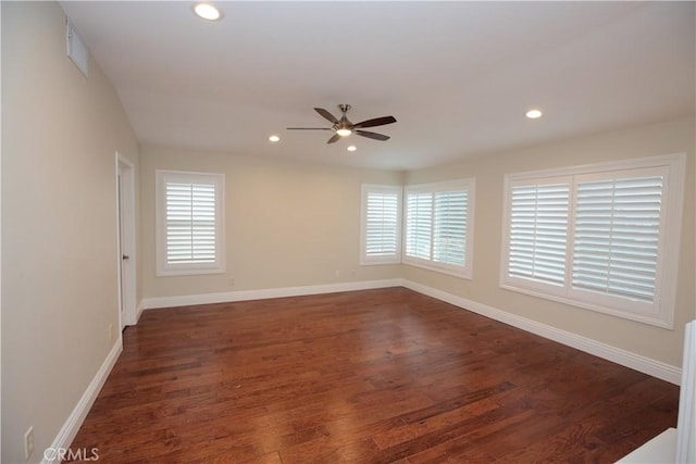 spare room featuring ceiling fan, dark hardwood / wood-style floors, and a healthy amount of sunlight