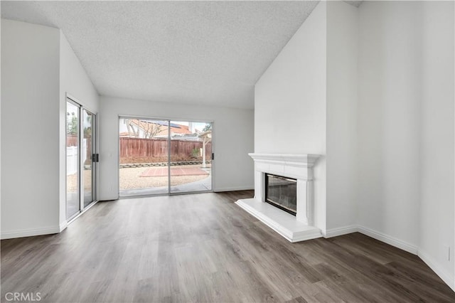 unfurnished living room featuring hardwood / wood-style flooring and a textured ceiling