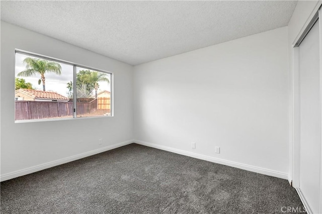 carpeted empty room with a textured ceiling