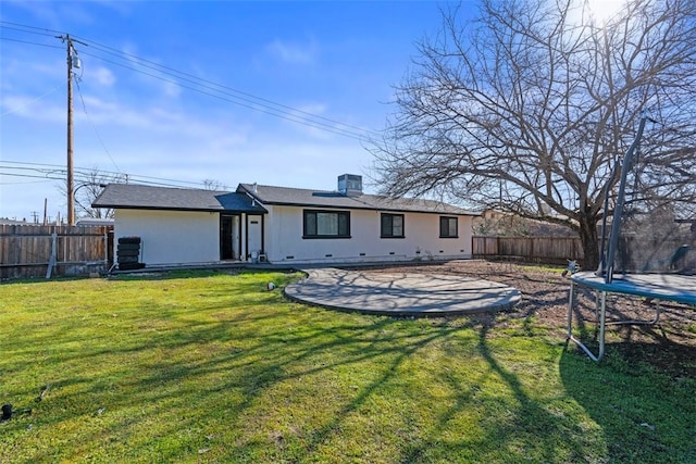 rear view of house featuring a trampoline, a yard, and a patio area