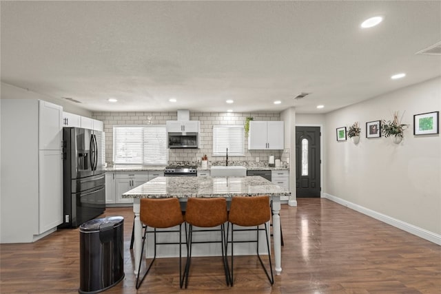 kitchen with appliances with stainless steel finishes, a center island, and white cabinets