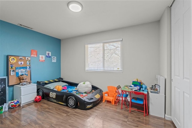 bedroom with hardwood / wood-style floors and a closet