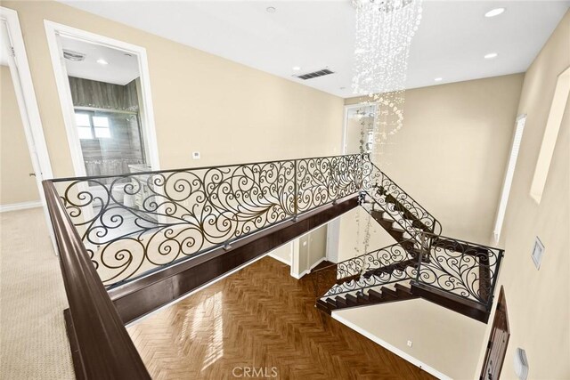 stairs with a chandelier