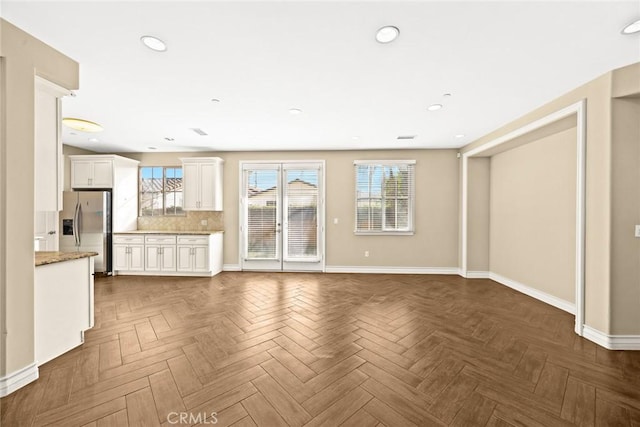 unfurnished living room featuring parquet floors