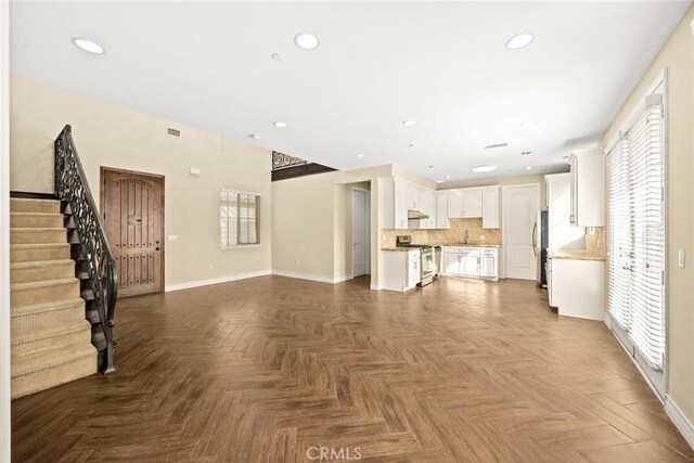 unfurnished living room with parquet floors and sink