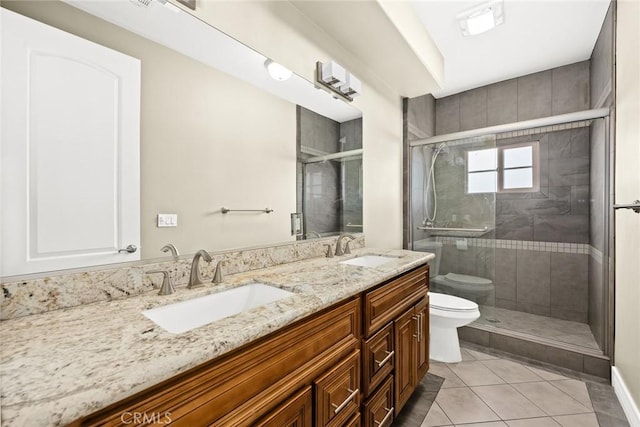 bathroom with tile patterned floors, toilet, a shower with shower door, and vanity