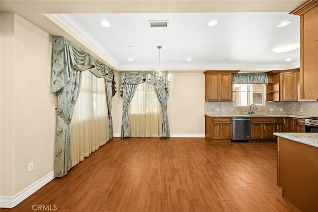 kitchen with hardwood / wood-style floors, decorative light fixtures, sink, stainless steel appliances, and crown molding