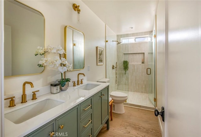 bathroom with vanity, hardwood / wood-style floors, a shower with door, and toilet