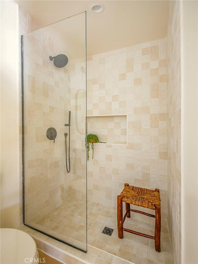 bathroom featuring a tile shower and toilet