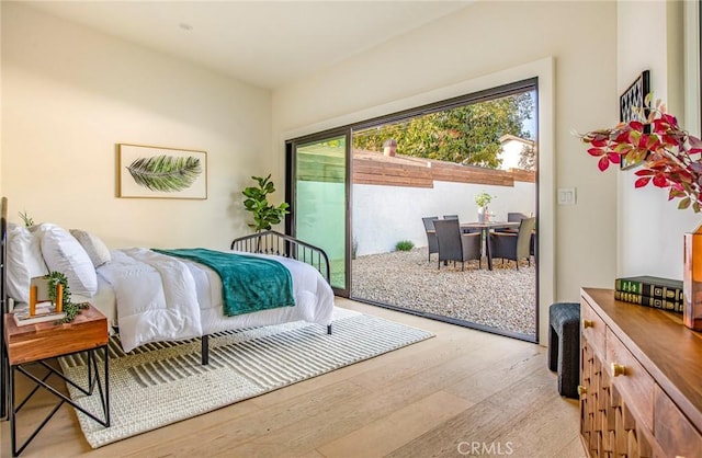 bedroom with multiple windows, access to exterior, and light wood-type flooring